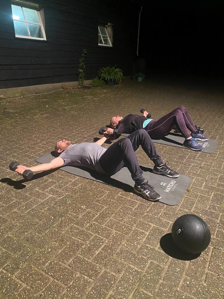 Twee mensen trainen in de avond op een verharde ondergrond