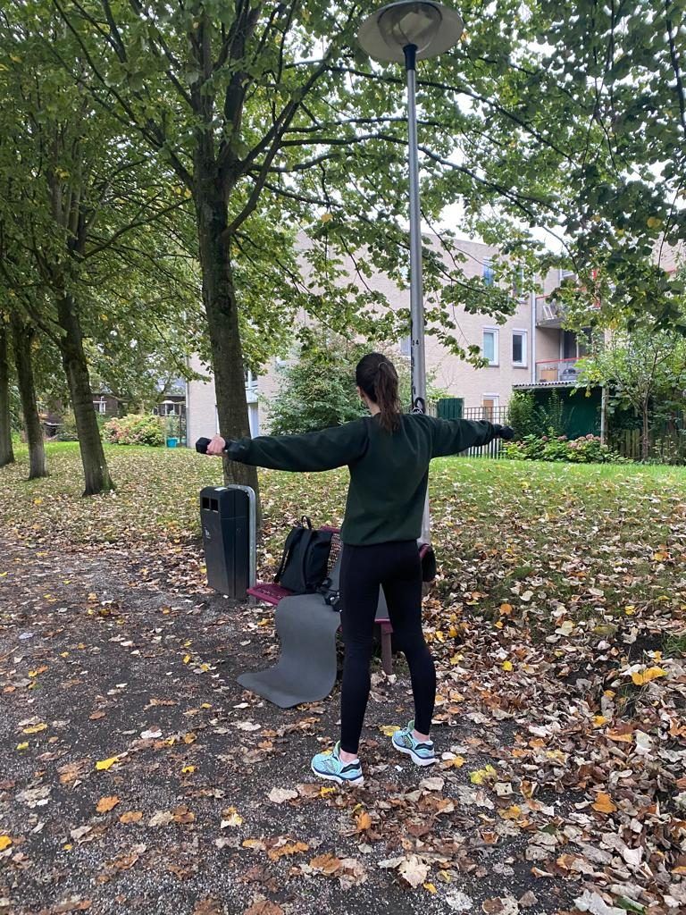 Vrouw rekt haar armen uit in een park